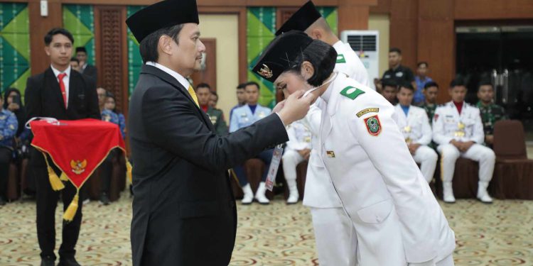 Wagub Kalsel H Hasnuryadi Sulaiman kalungkan medali kepada salah satu anggota Paskibraka Kalsel sebagai tanda ditutupnya Pemusatan Pendidikan dan Pelatihan Paskibraka Kalsel. (foto : adpim kalsel)