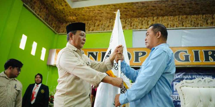 Ketua Umum Forki Kalsel H. Sahbirin Noor menyerahkan pataka Forki kepada Sensei Yanto. (foto : istimewa)