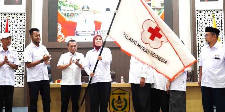 Hj Ananda yang terpilih menjadi Ketua PMI Banjarmasin kibarkan bendera PMI. (foto : shn/seputaran)
