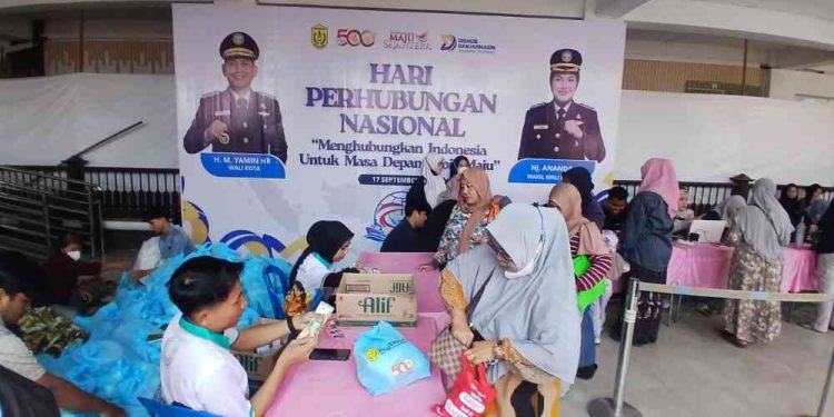 Warga saat menebus paket sembako di pasar murah Balai Kota Banjarmasin. (foto : shn/seputaran)