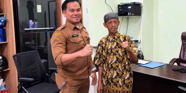 Plt Kabag Umum Setdako Banjarmasin Ahmad Zazuli saat menyerahkan bantuan kepada penerima. (foto : shn/seputaran)