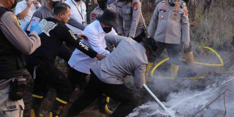 Gubernur Kalsel H Muhidin saat memadamkan bara di lahan gambut di Ring 1 Jalan Bandara Syamsudin Noor. (foto : adpim kalsel)