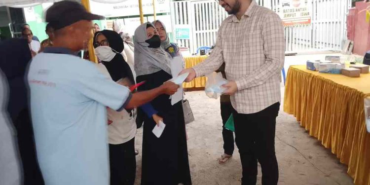 Ketua DPRD Banjarmasin Rikval Fachruri membagikan masker saat pelaksanaan reses. (foto : smr/seputaran)